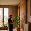 Conseiller expliquant installation d'œuvres d'art dans intérieur en bois chaleureux